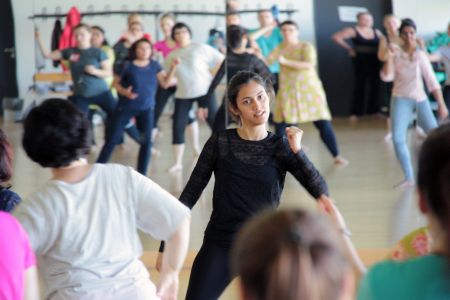 Workshop-Leiterin und Teilnehmer tanzen zu indischer Musik